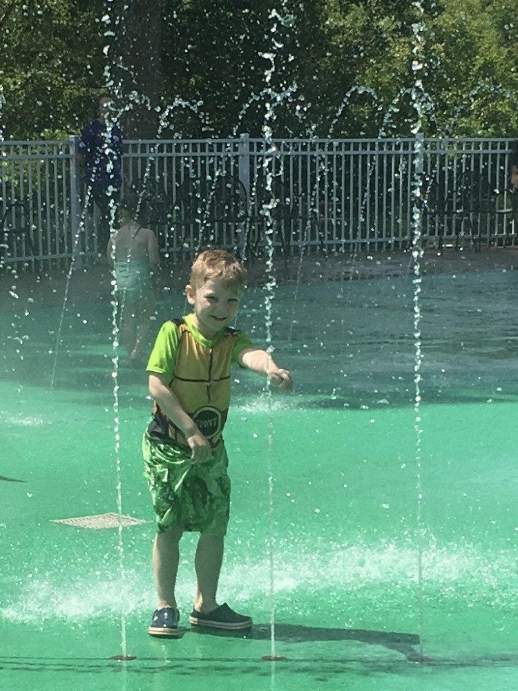 boy playing in sprinkler